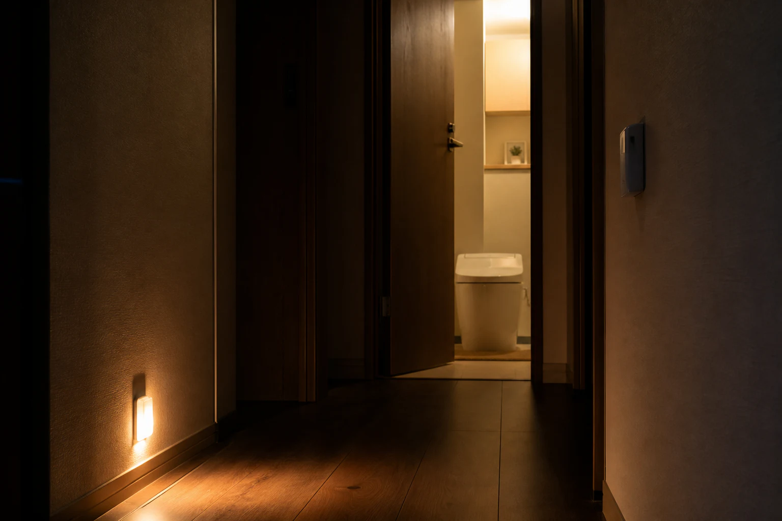 夜の廊下からトイレまで足元を照らす自動照明のイメージ